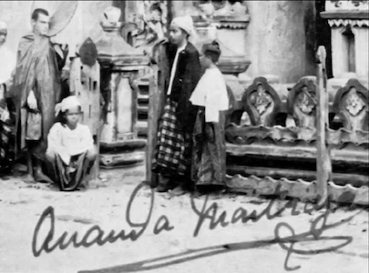Vintage photograph of people in traditional clothing before ornate stone temple, signed Ananda Metteyya