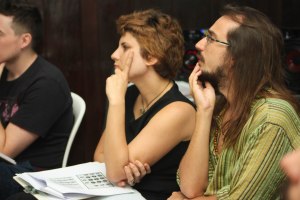 Three people sitting together, looking focused and listening attentively