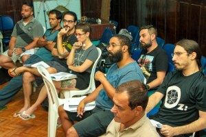 A group of people sitting in chairs and listening attentively