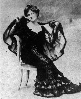 Vintage black-and-white photograph of a seated woman with updo, wearing a fur-lined cloak