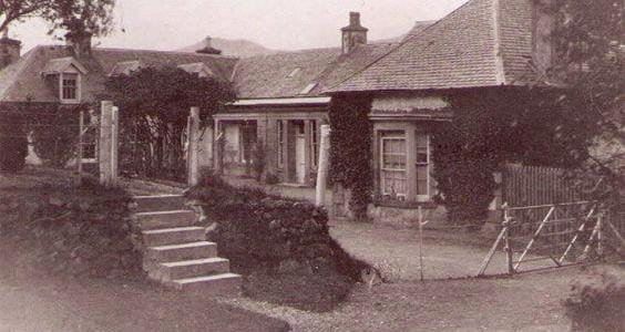 Vintage sepia photo of stone cottage with tiled roof and small garden staircase